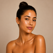 Woman with a neutral expression against a beige background