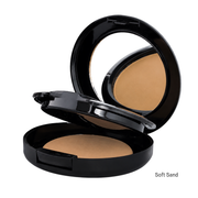 An open black round compact powder foundation with a mirror on the inside lid, showing a light tan pressed powder labeled 'Soft Sand' on a white background.