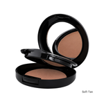 Load image into Gallery viewer, An open round black makeup compact showing a foundation powder in a warm tan shade, with a mirror on the inside of the lid. The text 'Soft Tan' appears in the bottom right corner on a plain white background.