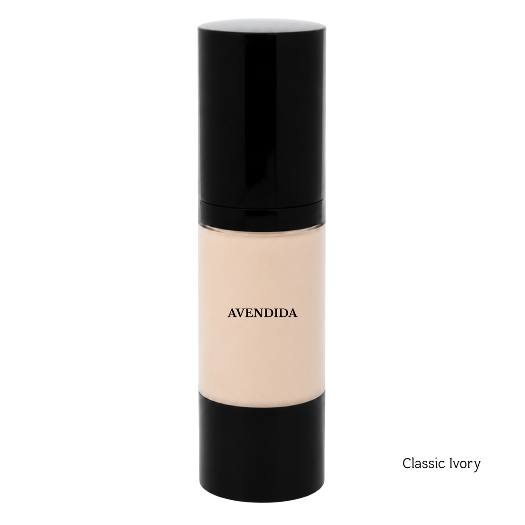 A bottle of Avendida Classic Ivory liquid foundation with a black cap and base, showing the beige foundation inside, on a white background with 'Soft Ivory' text in the bottom right corner.