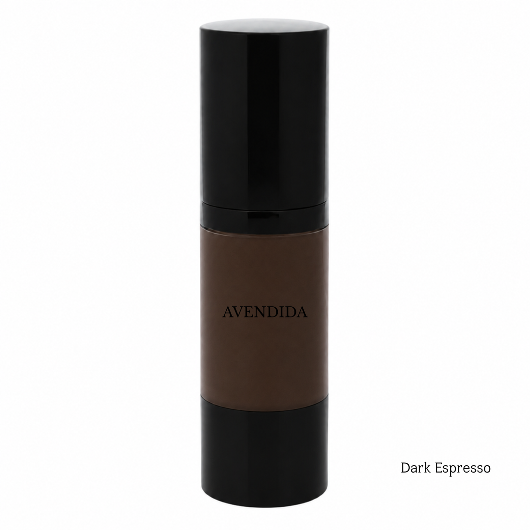 A bottle of AVENDIDA liquid foundation in the shade Dark Espresso, featuring a dark brown liquid visible through a clear cylindrical bottle with a glossy black cap and base, set against a plain white background.