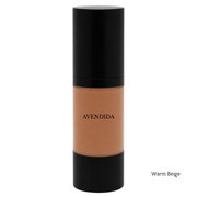 A bottle of AVENDIDA liquid foundation in the shade Warm Beige, featuring a black cap and base with the beige makeup visible through the clear center bottle, on a white background.